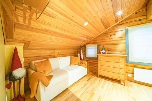 a living room with a white couch in a wooden room at Beautiful cottage in Lapland ! in Kittilä