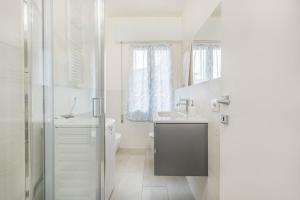 une salle de bain blanche avec un lavabo et des toilettes dans l'établissement Mutina Design Suite - City life & Hesperia Hospital, à Modène