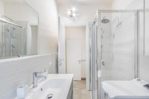 une salle de bain blanche avec lavabo et douche dans l'établissement Mutina Design Suite - City life & Hesperia Hospital, à Modène