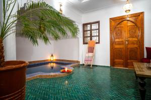 a room with a pool with a table and a door at Riad Dekkak - Traditional Private Riad in Marrakesh