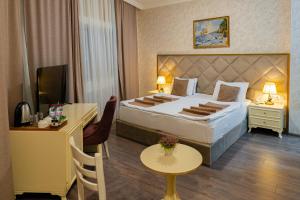 pokój hotelowy z dużym łóżkiem i stołem w obiekcie Salam Baku Hotel (SBH) w mieście Baku