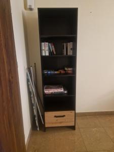 a book shelf filled with books next to a wall at Noclegi Opole-Chmielowice Apartament B in Opole