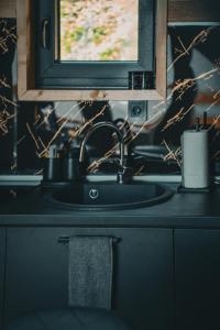 a kitchen counter with a sink and a mirror at Oaza mira HaDaNa in Tihovići