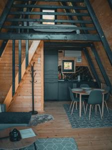 a kitchen and dining room in a cabin with a table at Oaza mira HaDaNa in Tihovići +14 photos