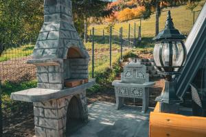 a stone oven with a lamp next to a yard at Oaza mira HaDaNa in Tihovići