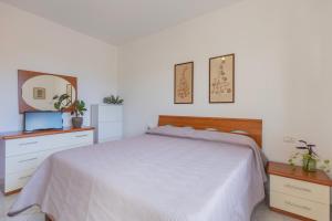 a white bedroom with a bed and a mirror at Appartamento ElbaBlu by ElbaSummer Tour Operator in Lacona +9 photos