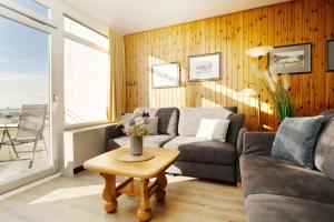 a living room with a couch and a table at Strandhaferweg 7 Möwenoase in Burgtiefe auf Fehmarn 