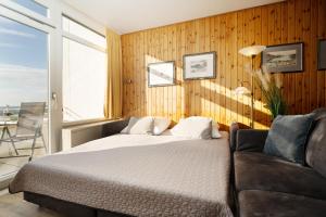 a bedroom with a bed and a couch at Strandhaferweg 7 Möwenoase in Burgtiefe auf Fehmarn  +18 photos