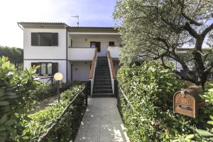 a house with a staircase leading up to it at Appartamento ElbaBlu by ElbaSummer Tour Operator in Lacona