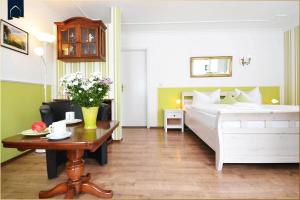 een slaapkamer met een bed en een tafel met bloemen bij Haus Lindenstraße (051) An den Linden in Heringsdorf