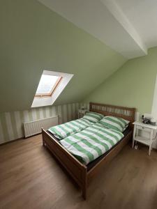 a bedroom with a bed in a attic with a window at Apartmán u Čertova mlýna Zelezna Ruda in Špičák