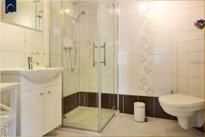 een badkamer met douche, toilet en wastafel bij Haus Lindenstraße (051) An den Linden in Heringsdorf