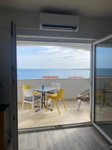 a table and chairs on a balcony with a view of the ocean at Apartments Matosevic-Pag in Pag