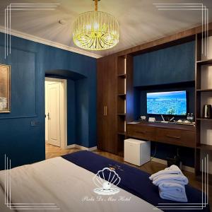 a blue bedroom with a bed and a television at Perla De Mar Hotel & Restaurant in Baku