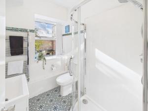 a white bathroom with a toilet and a shower at Harbour Haven Steps from Torquay Port in Torquay +9 photos