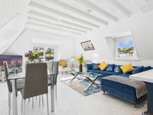 a living room with a blue couch and a table at Harbour Haven Steps from Torquay Port in Torquay