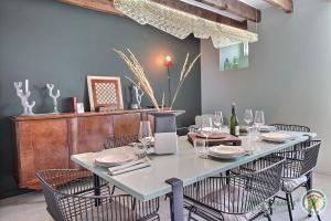 uma sala de jantar com uma mesa com cadeiras e copos de vinho em De rulinen em Saint-Clet