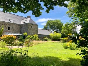 a stone house with a lawn in front of it at De rulinen in Saint-Clet