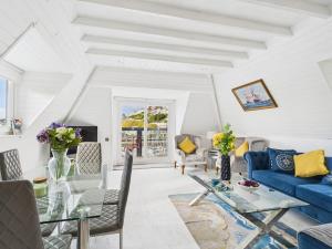 a living room with a blue couch and a table at Harbour Haven Steps from Torquay Port in Torquay