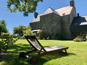 uma cadeira sentada na relva em frente a um edifício em De rulinen em Saint-Clet