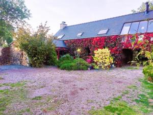 um edifício com flores ao lado em De rulinen em Saint-Clet mais 27 fotografias