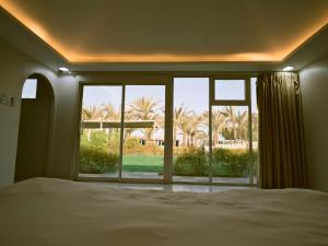 a bedroom with a bed and a large glass window at Palm Escape Farmhouse - By Seven Elements in Ras al Khaimah +25 photos