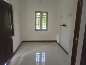 een lege kamer met een raam en een witte muur bij White House Home Stay! in Kaup