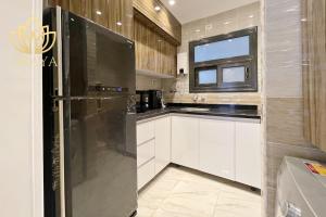 eine Küche mit Edelstahlkühlschrank und Fenster in der Unterkunft Modern & Bright Getaway in Madinaty in Banī Ghālib