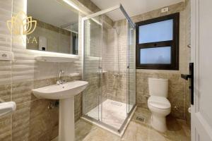 ein Badezimmer mit Toilette, Waschbecken und Dusche in der Unterkunft Modern & Bright Getaway in Madinaty in Banī Ghālib