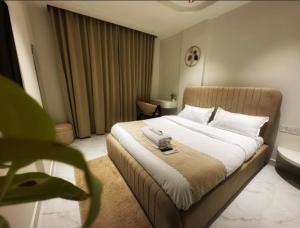 a bedroom with a bed with a phone on it at Lux Living Hotel in Bengaluru