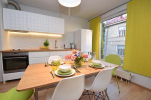 a kitchen with a wooden table with white chairs and a dining room at Bright Home in Tallinn