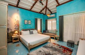 ein Schlafzimmer mit einem Bett und einer blauen Wand in der Unterkunft Sisodia Bagh Luxury Boutique Resort-Jaipur in Jaipur + 97 Fotos