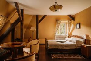 a bedroom with a bed and a table and a window at Villa Pepita in Miedzygorze