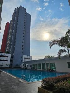ein Gebäude mit einem Swimmingpool vor einem Gebäude in der Unterkunft Ipoh Anderson Condo - 2BR in Ipoh