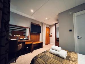 une chambre d'hôtel avec un lit et un bureau avec un ordinateur dans l'établissement The Golf Hotel Woodhall Spa, à Woodhall Spa