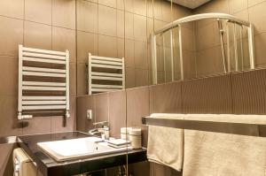 ウッチにあるHome & Travel Apartments - AC - Parking - City Centre - Manufaktura - OFF Piotrkowska - EC1 - ATLAS Arena - Orientarium - Monopolisの洗面台と鏡のあるバスルーム +160枚の写真