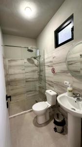 ein Badezimmer mit Toilette, Waschbecken und Dusche in der Unterkunft Hostel Vila H in Tirana