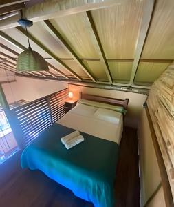 a small room with a bed and a lamp at Beach Bungalow Saquarema in Ipitangas
