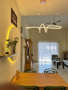 a dining room with a table and chairs and a chandelier at Comfort Stay Calangute beach Goa in Serula
