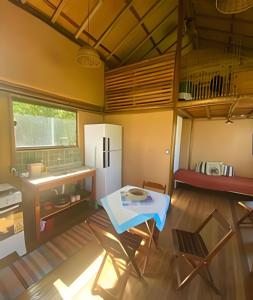 a small kitchen with a table and a refrigerator in a room at Beach Bungalow Saquarema in Ipitangas