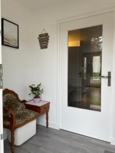 a room with a door with a chair and a plant at Gîte Aux Portes de Bellevue in Salbris