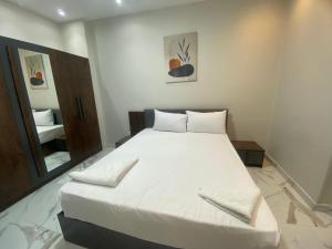 a white bed in a room with a mirror at Golden Ibis Memphis in Cairo