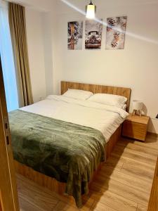 a bedroom with a large bed with white sheets at Titik Apartments Mavrovo in Mavrovo