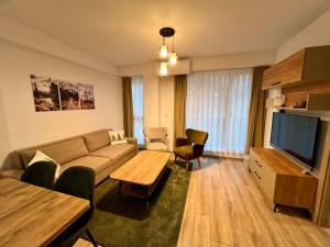 a living room with a couch and a table at Titik Apartments Mavrovo in Mavrovo