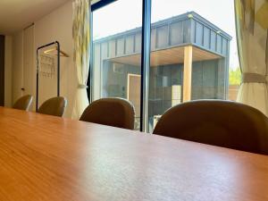 une salle de conférence avec une table et des chaises en bois dans l'établissement Lohas Resort 芥屋A, à Itoshima