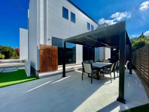 un patio avec une table et des chaises à côté d'un bâtiment dans l'établissement Lohas Resort 芥屋A, à Itoshima