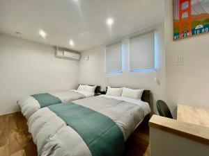 deux lits dans une chambre avec deux fenêtres dans l'établissement Lohas Resort 芥屋A, à Itoshima 50 autres photos