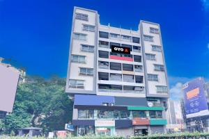 a tall white building with a qo sign on it at Hotel O EKAB Hospitality in Mundhwa +26 photos