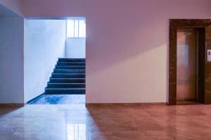 a hallway with stairs in a building at Hotel O EKAB Hospitality in Mundhwa +26 photos