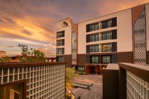 彭世洛Wangkaew Hotel的公寓大楼的背景是日落